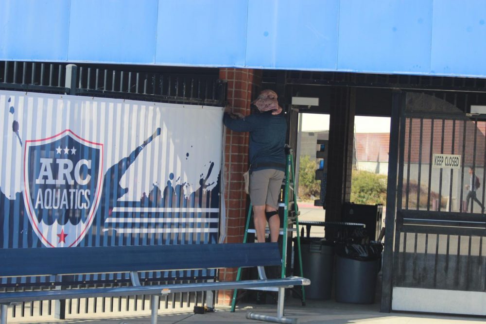 A new windscreen is put up in the aquatic center at American River College to protect the privacy of its swimmers during practice on Oct. 28, 2019. (Photo by Thomas Cathey)