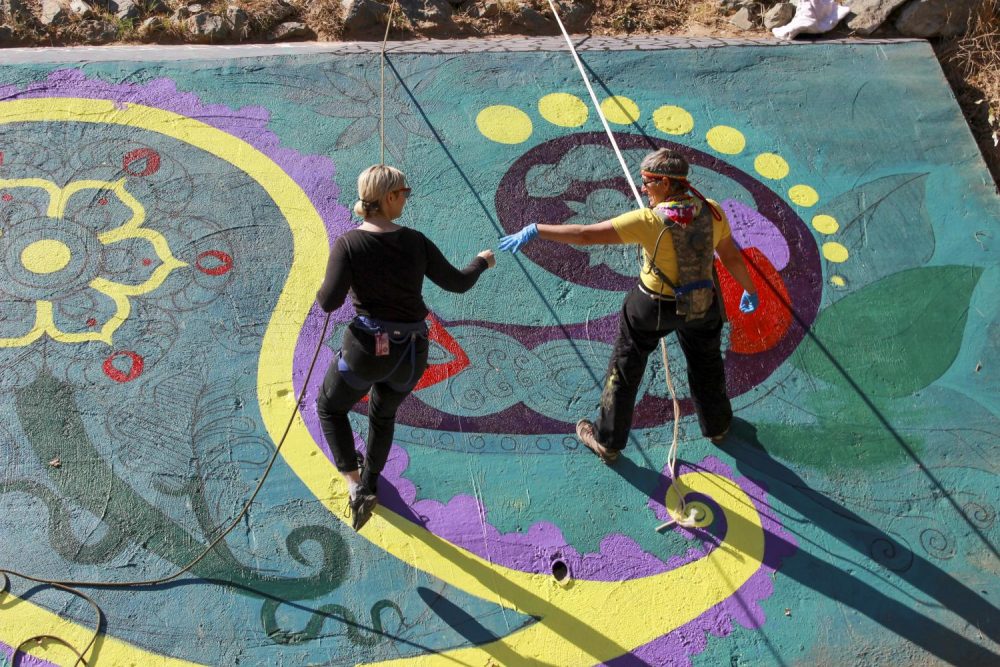 Jade Jacobs and Renee Marie painting a new bridge mural at American River College on Oct. 15, 2019. (Photo by Colin Bartley)