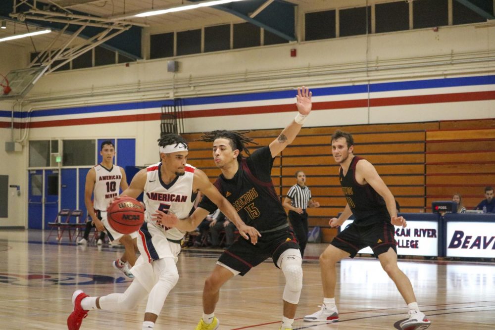 American+River+College+guard+Jashon+Lewis+pushes+past+Redwoods+player+EJ+Jackson+on+Nov.+7+2019.+%28Photo+by+Colin+Bartley%29