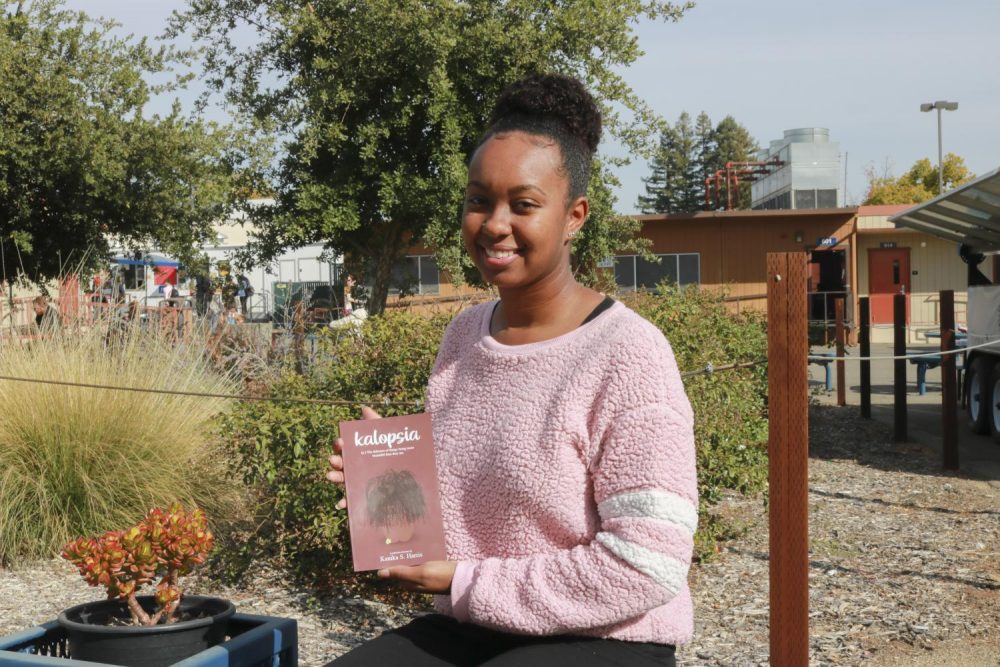 Writer Kanika Harris, pictured here at American River College on Nov. 12, 2019, with her new book of poetry. Kalopsia, explores the beauty and struggle of the transition into adulthood. (Photo by Bram Martinez)