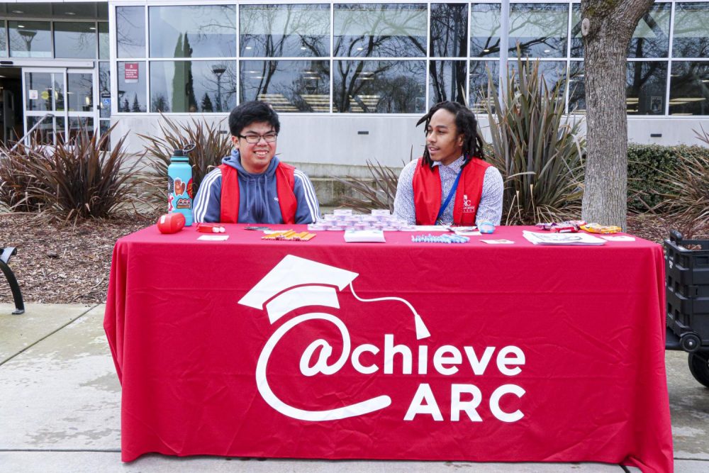 In front of  the American River College Library on Jan. 22, Nursing major Von Vega (left) and Psychology major Joaquin Holland (right), Student Support for Achieve at ARC, are ready at their table and eager to help the new students. (Photo by Bram Martinez)
