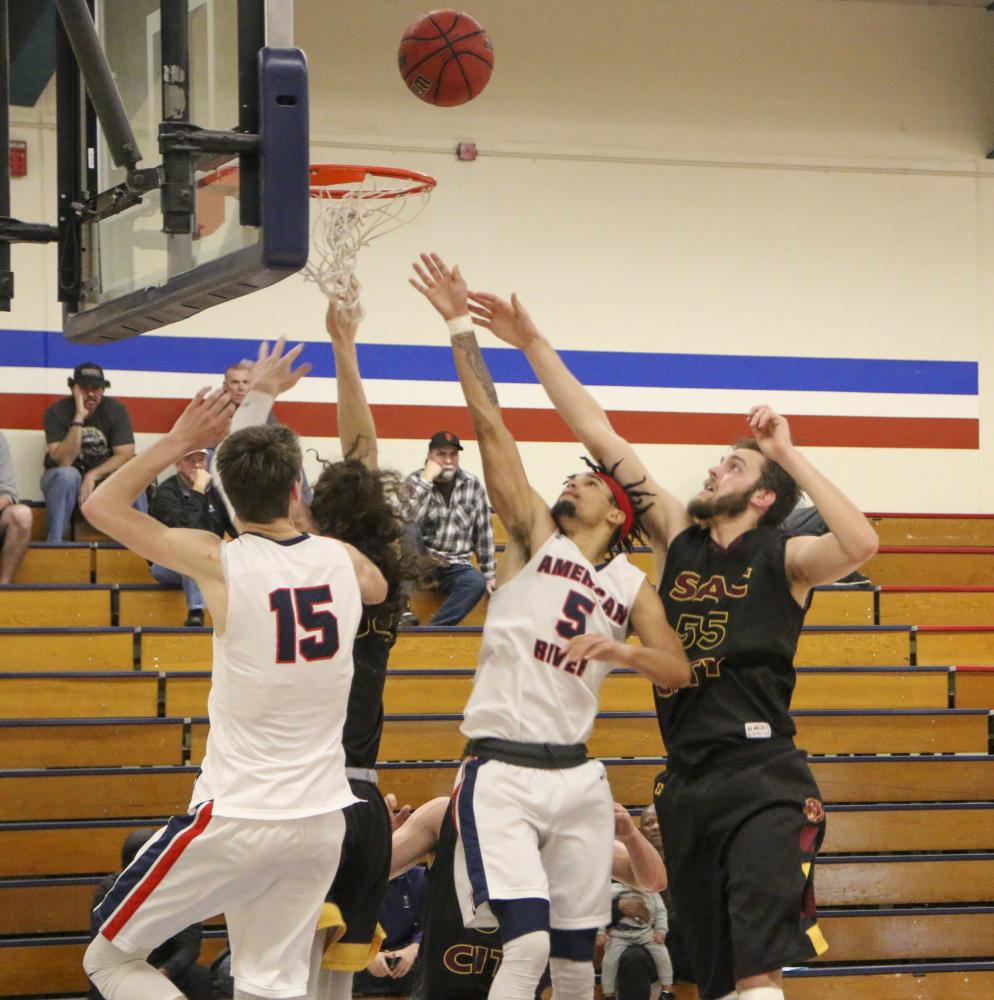 Sophomore Jashon Lewis works with teammate freshman David O’Looney to get a rebound in their game against Sacramento City College on Jan 24, 2020. (Photo by Josh Ghiorso)