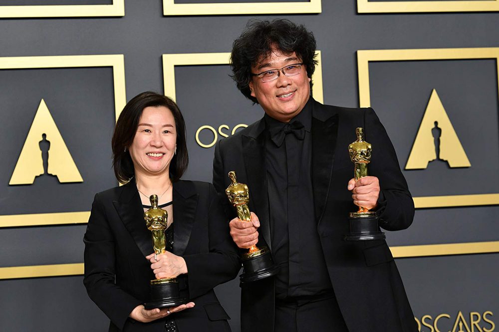 Bong Joon Ho and Kwak Sin Ae pose with their awards at the Oscars. (Photo Courtesy of IMDB).