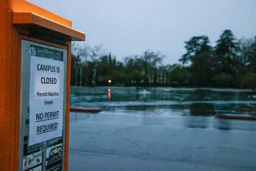 A sign that reads ‘Campus Is Closed No Permit Required’ hangs on the ticket kiosk in an empty parking lot at American River College on March 16, 2020. Since the Los Rios Community College closed its campuses, students’ classes are now converted to online until further notice. 

