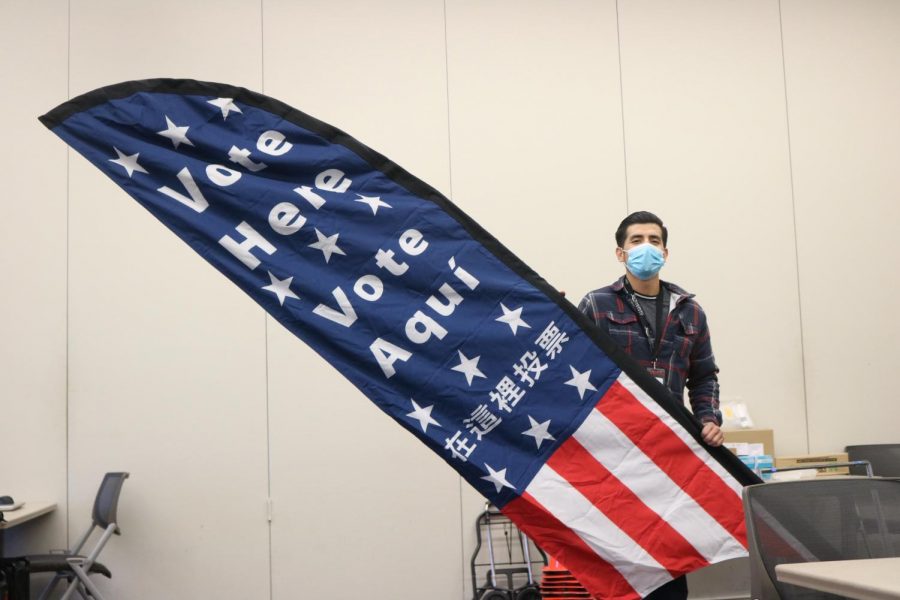 Jorge Perez, Sacramento County election assistant, helps set up ballot machines and signs for the voting center at American River College on Oct. 29, 2020. (Photo by Emily Mello)