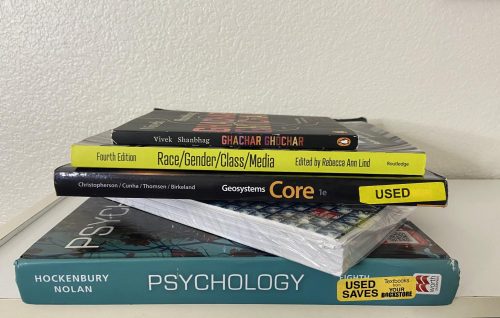 Many student’s textbooks  are starting to pile up because it is challenging to sell them back. Professors need to take the time to research different, more affordable and accessible options for their students instead. (Photo illustration by Maya Barber)
