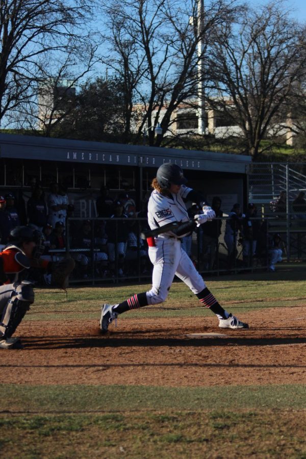 American River College Left Fielder Christian Restori swings and gets an infield single. (Photo by Jonathan Plazola)